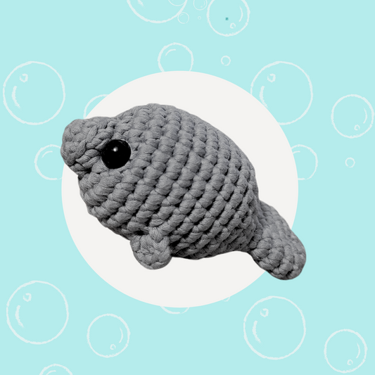 Crocheted gray manatee plush named Milo the Manatee from Little Loop Company, displayed on a light blue background with bubbles.