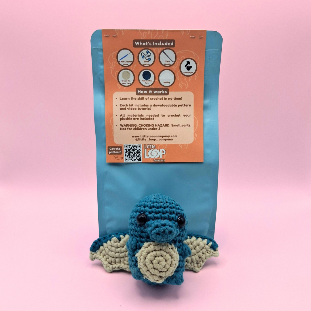 Back view of Ember the Dragon crochet kit packaging showing finished dragon plush and kit details.