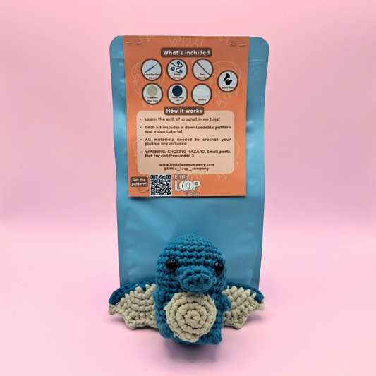 Back view of Ember the Dragon crochet kit packaging showing finished dragon plush and kit details.