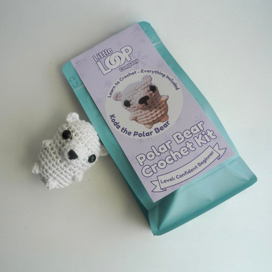 Crochet kit with a polar bear amigurumi and packaging on a white background